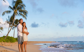 Влюбленная пара встречает закат на берегу океана