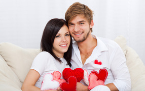 Красивая влюбленная пара с маленькими сердечками в руках