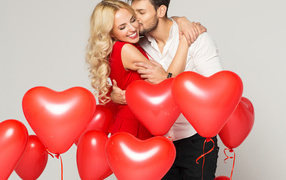 Happy loving couple with balloons in the shape of heart