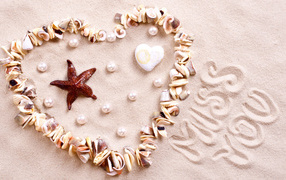 Heart of seashells on sand