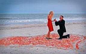 Romantic offer of a hand and a heart by the sea