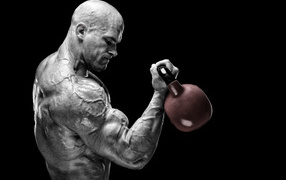 Сильный накаченный мужчина бодибилдер с гантелей в руках