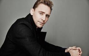 Актер Том Хиддлстон в черном пальто 