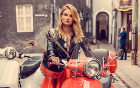 Красивая девушка блондинка в черной куртке на красном мотоцикле