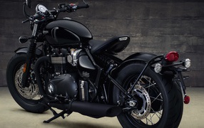 Черный мотоцикл Triumph Bonneville Bobber, 2018 вид сзади