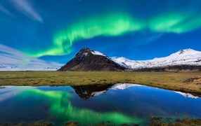 Северное сияние над заснеженными горами 