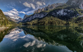 Сосны и горы отражаются в озере  