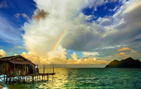 Радуга  над бунгало на тропическим пляжем 