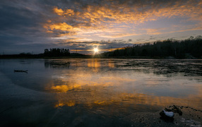 Рассвет холодного солнца над заледеневшим озером