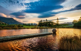 Деревянный мост в озере на закате солнца