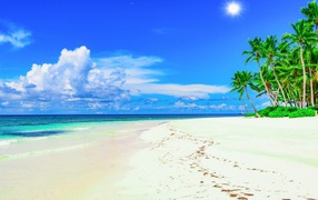 Следы на белом песке на тропическом пляже под красивым голубым небом