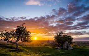 Летний рассвет солнца в облачном небе укрывает землю