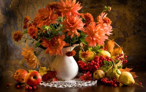 Букет георгин в вазе на столе с грушами и ягодами рябины