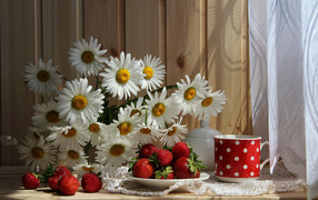Букет белых ромашек на столе с клубникой