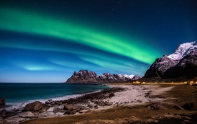 Beautiful northern lights in the starry sky above the mountains, Lofoten Islands. Norway
