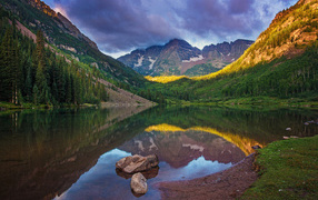 Покрытые зеленью горы отражаются в чистой воде озера