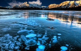 Покрытое льдом чистое  озеро Эйбрахам на фоне гор, Канада