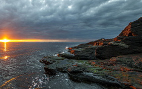 Каменное побережье в Норвегии на закате 