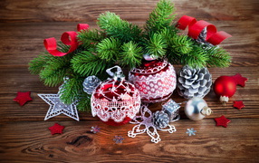 Красивые елочные игрушки с зеленой еловой веткой на деревянном столе 
