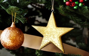 Золотая звезда и шар на новогодней елке