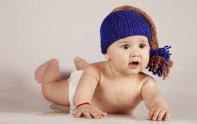 A brown-eyed baby in a knitted woolen hat
