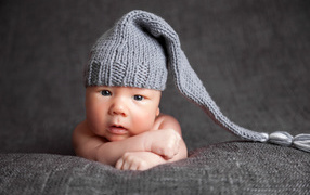 Милый младенец в большой серой вязаной шапке