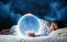 Маленький мальчик во сне держит в руках волшебную голубую луну