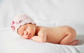 A sleeping baby girl in a pink hat