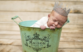 A sleeping baby with a crown on his head