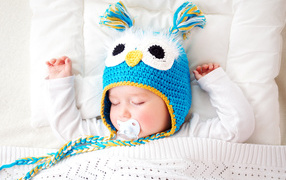 Спящий ребенок в забавной вязаной шапке