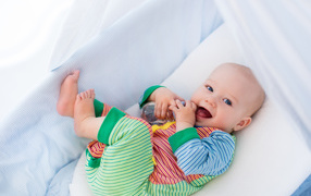 Маленький грудной ребенок в кроватке