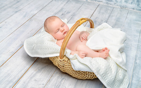 Маленький младенец спит в корзине