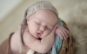 Маленький грудной ребенок спит в вязаной шапке