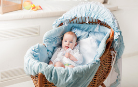 Маленький голубоглазый младенец в кроватке