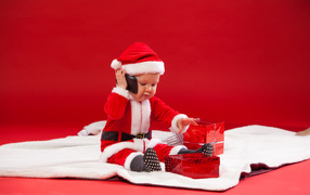 Маленький ребенок в новогодней униформе с подарками