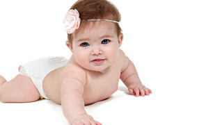 Baby girl with a flower on her head on a white background