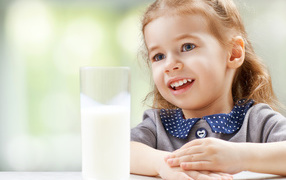 Beautiful brown-eyed girl with a glass of milk