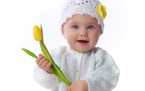Голубоглазая маленькая девочка с желтым тюльпаном в руках