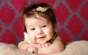 Милая маленькая девочка с цветком в волосах 