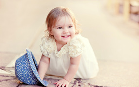 Милая улыбающаяся девочка в белом платье