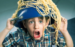 Смешной мальчик со спагетти на голове