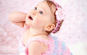 Заинтересованный взгляд маленькой девочки в красивом платье