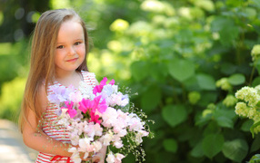 Русоволосая девочка с букетом цветов в руках