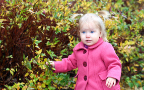 Little blue-eyed girl in a pink coat