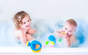 Little boy and girl bathe in the bathroom with toys