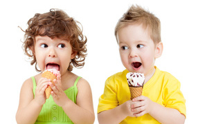 Маленькие мальчик и девочка едят вкусное мороженое