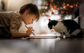 Little boy drawing with a cat