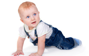 Little boy in blue overalls on white background