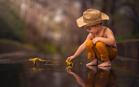 Little boy playing with frogs