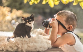 Little boy taking pictures of a kitten